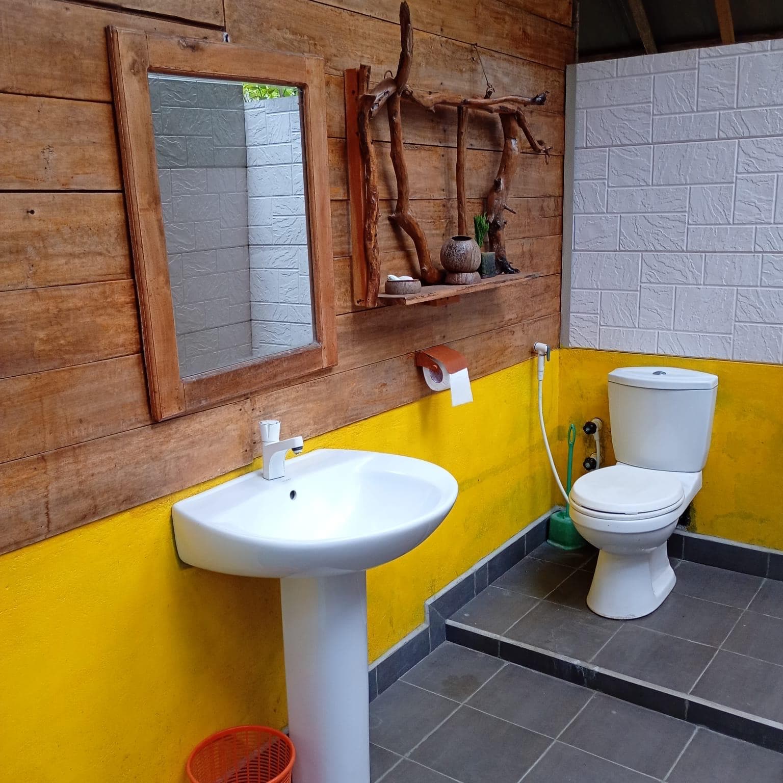 Bathroom sink and mirror against timber and yellow walls