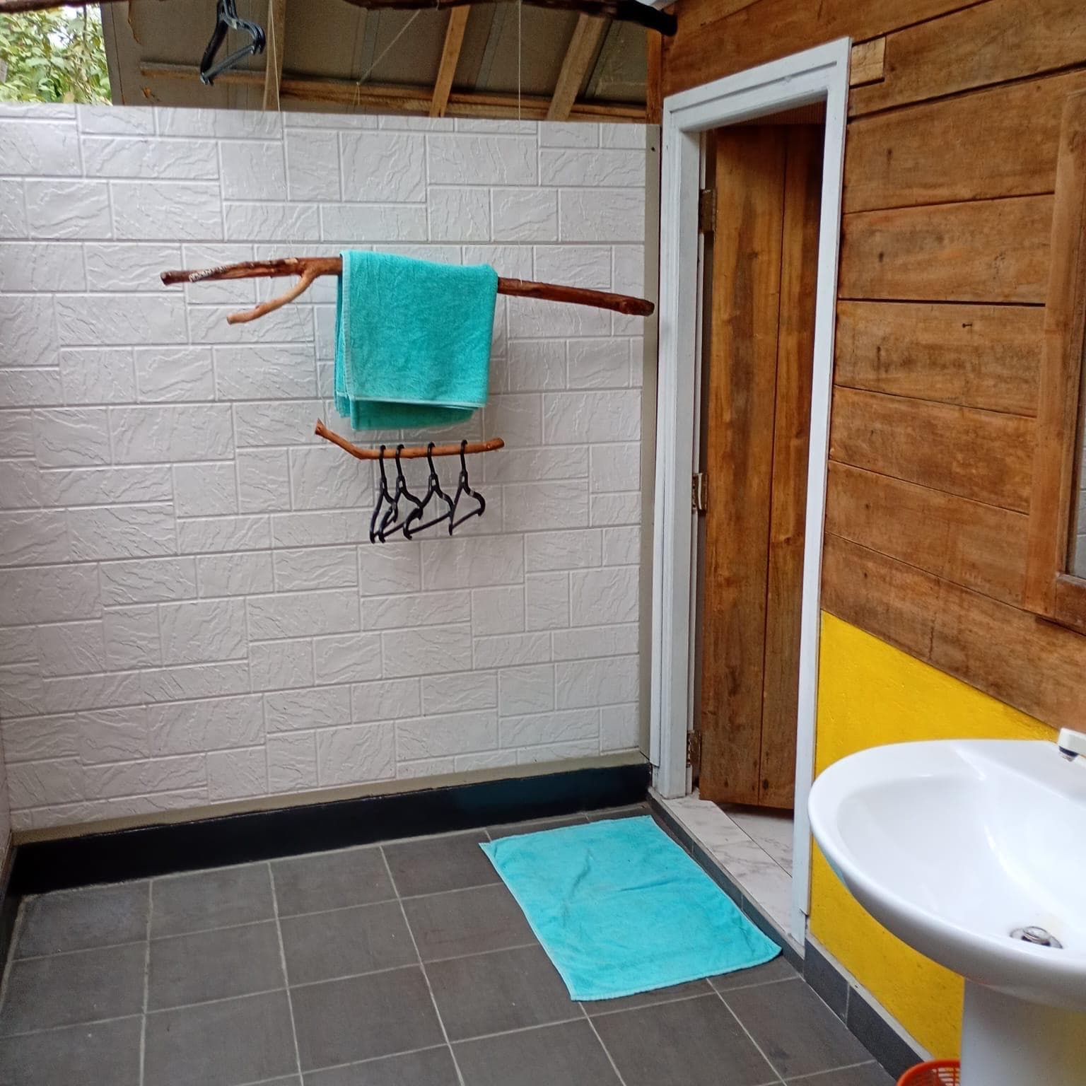 Fresh towels on a driftwood rail in the open-air bathroom