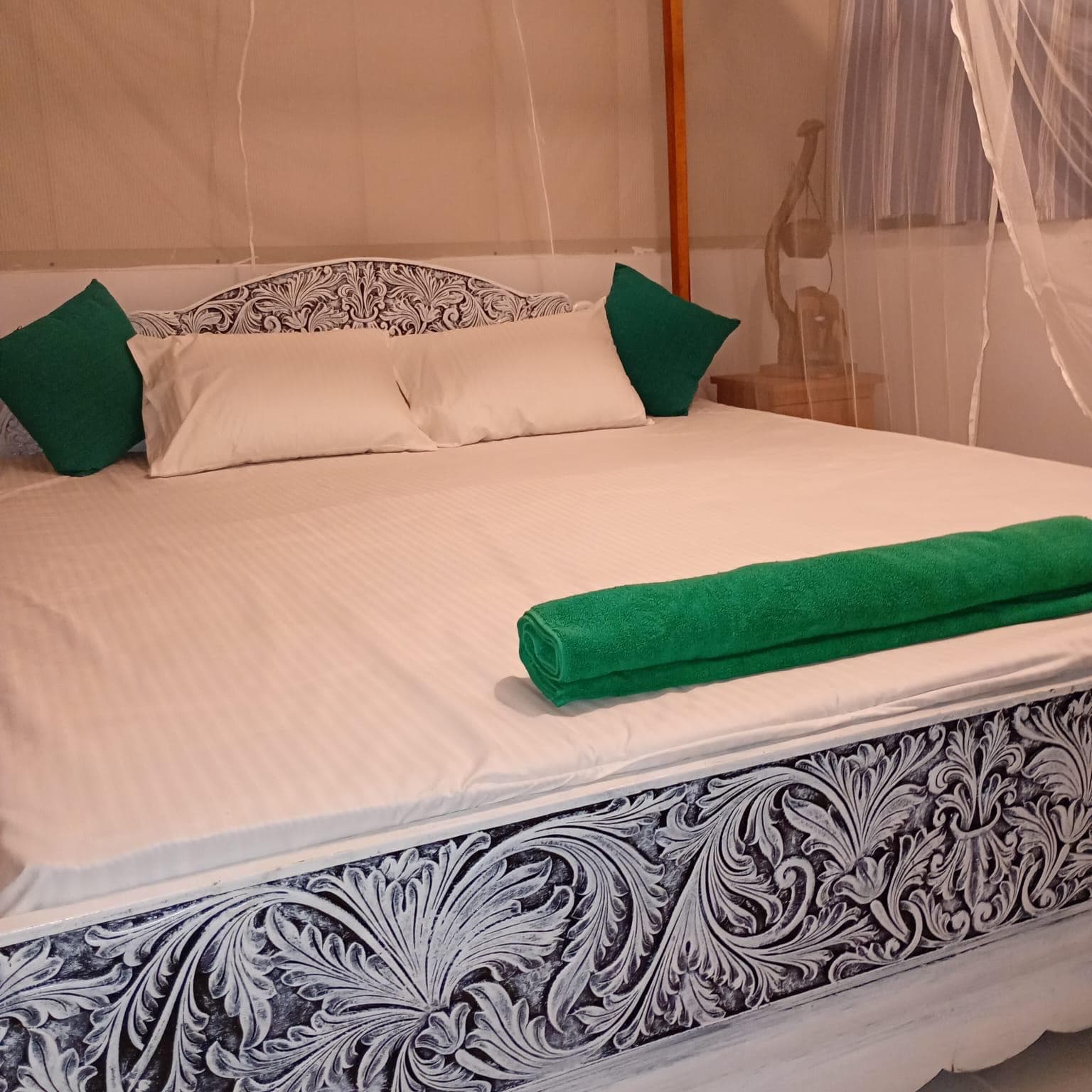 Carved four-poster bed made up with fresh linen