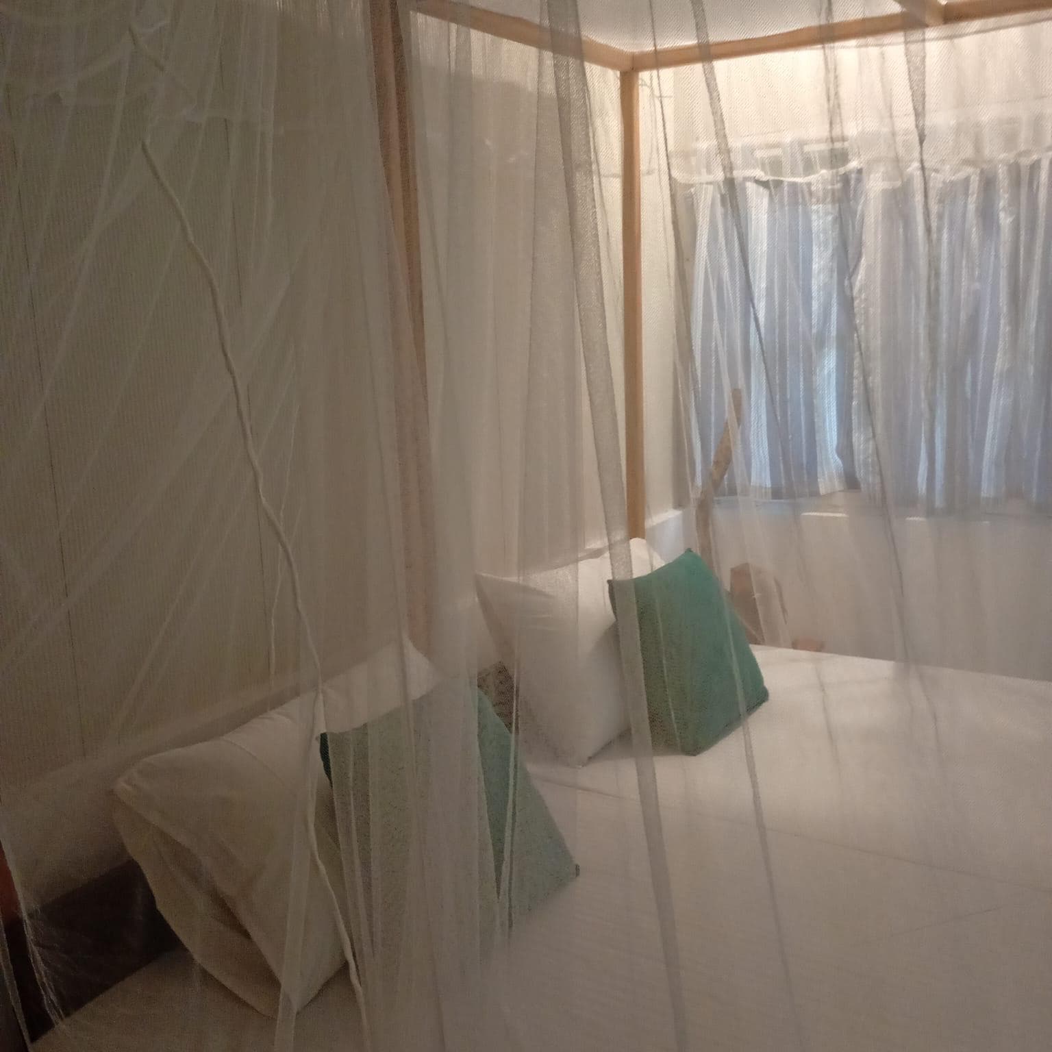 The bed seen through its mosquito-net canopy