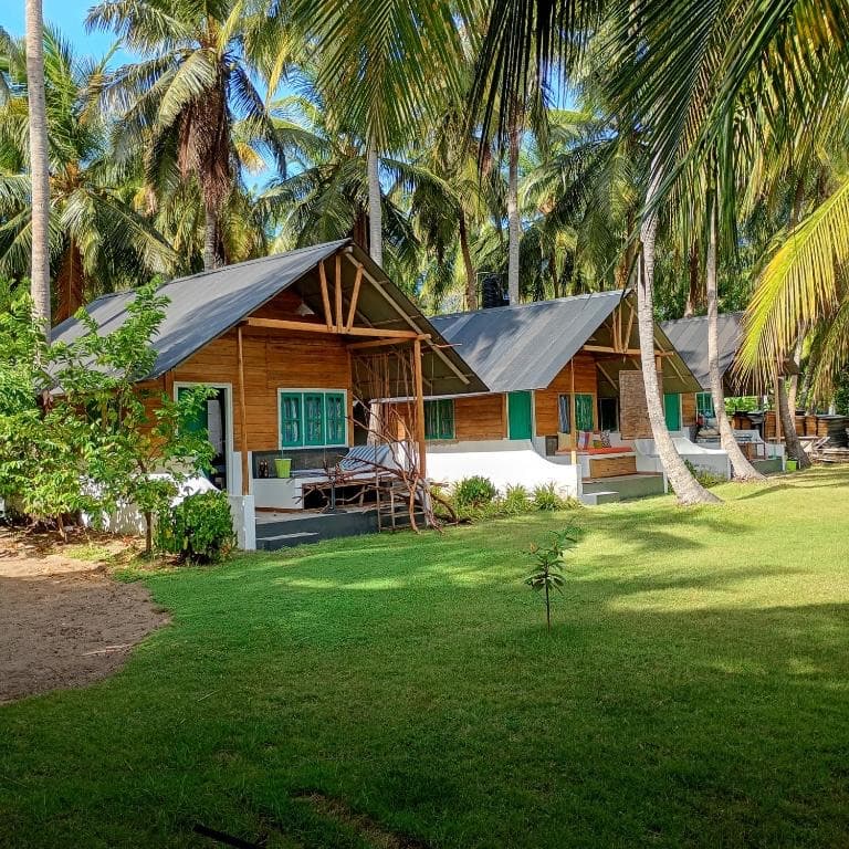 The row of cabanas across the lawn under tall palms