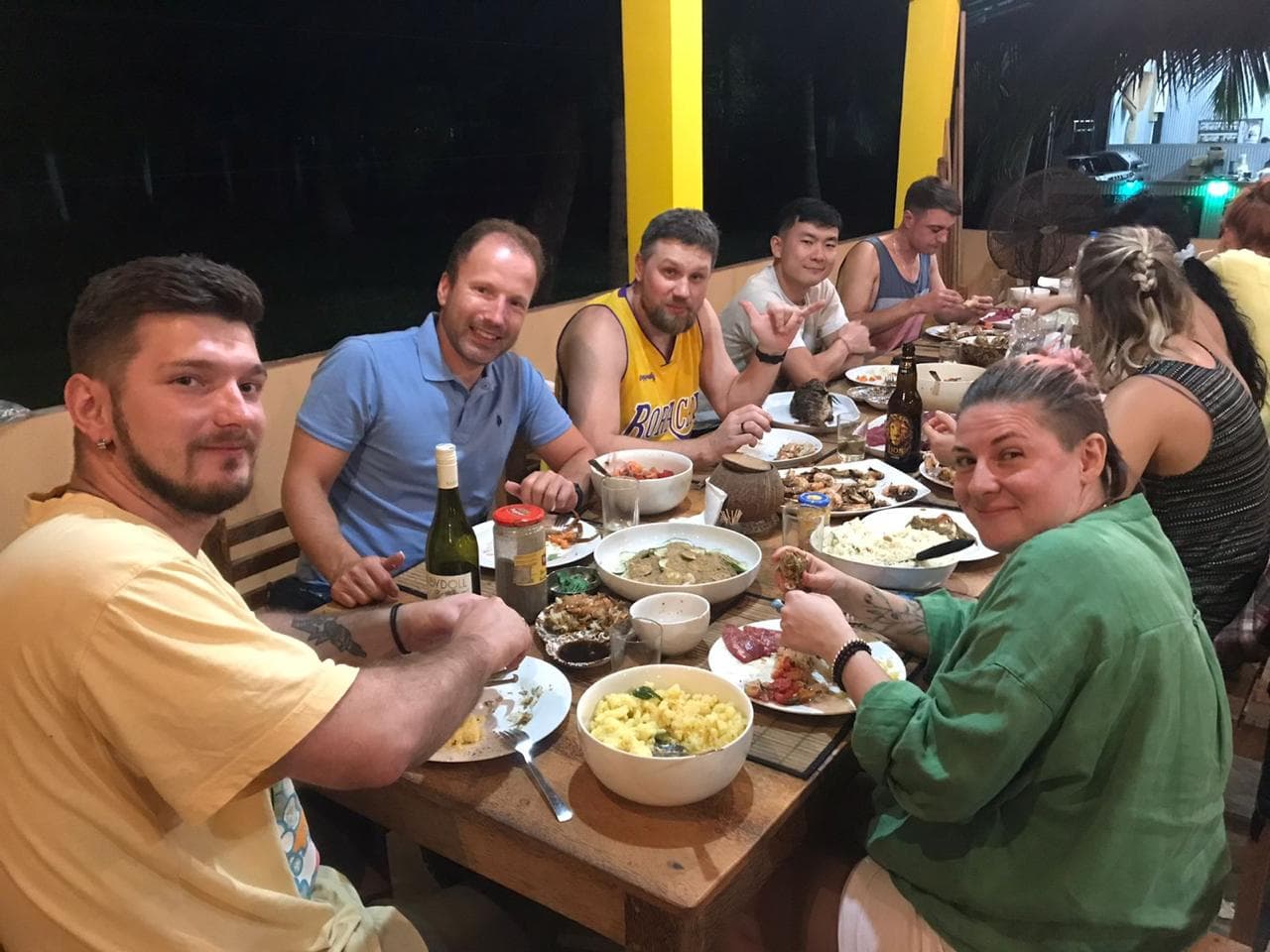 Guests sharing dinner at the long table in the evening